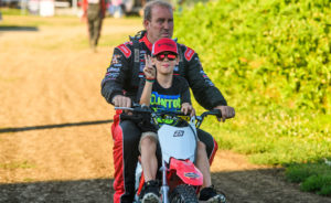 Shane Clanton riding a pit bike with his son