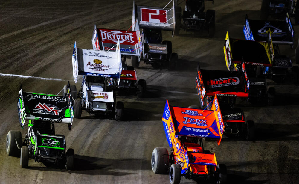 A pack of World of Outlaws Sprint Cars take the green flag out of Turn 4