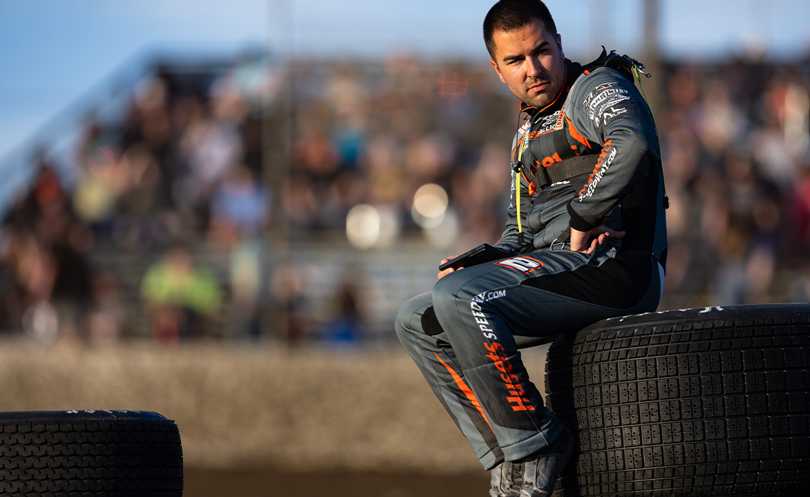 David Gravel sits atop a tire watching Qualifying