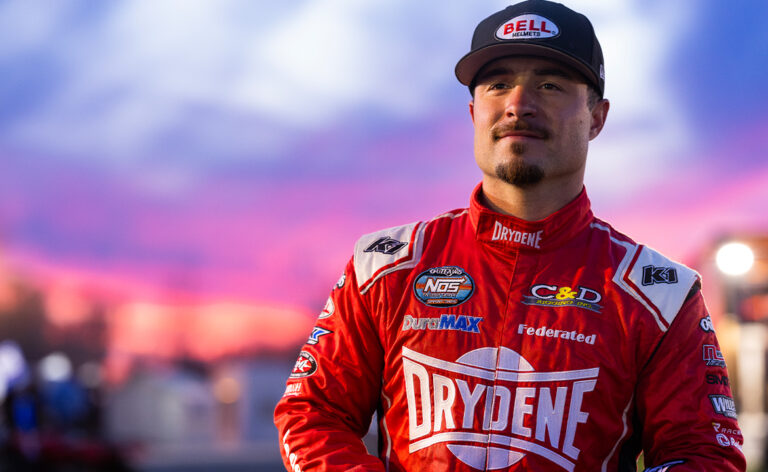 Logan Schuchart standing in his red Drydene firesuit