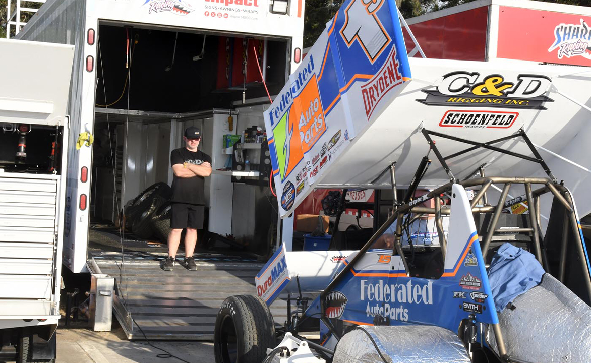 Kyle Pruitt standing in the Shark Racing hauler
